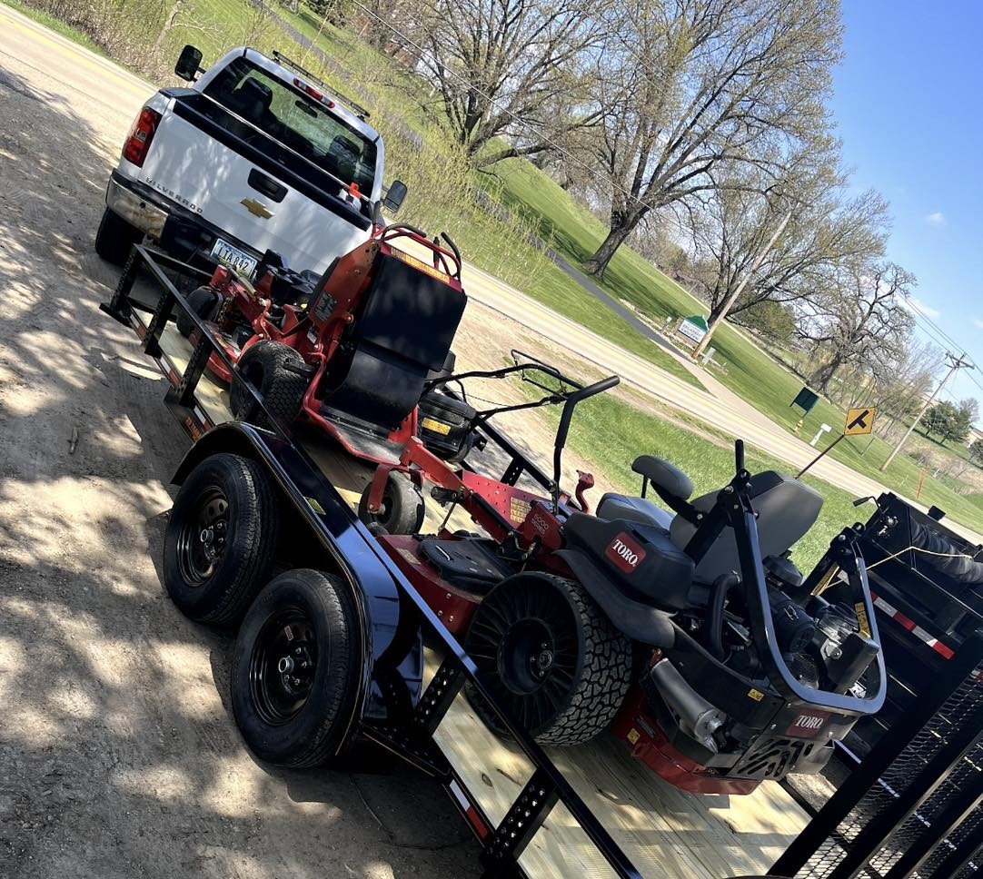 Silverado truck towing a trailer of Toro mowers